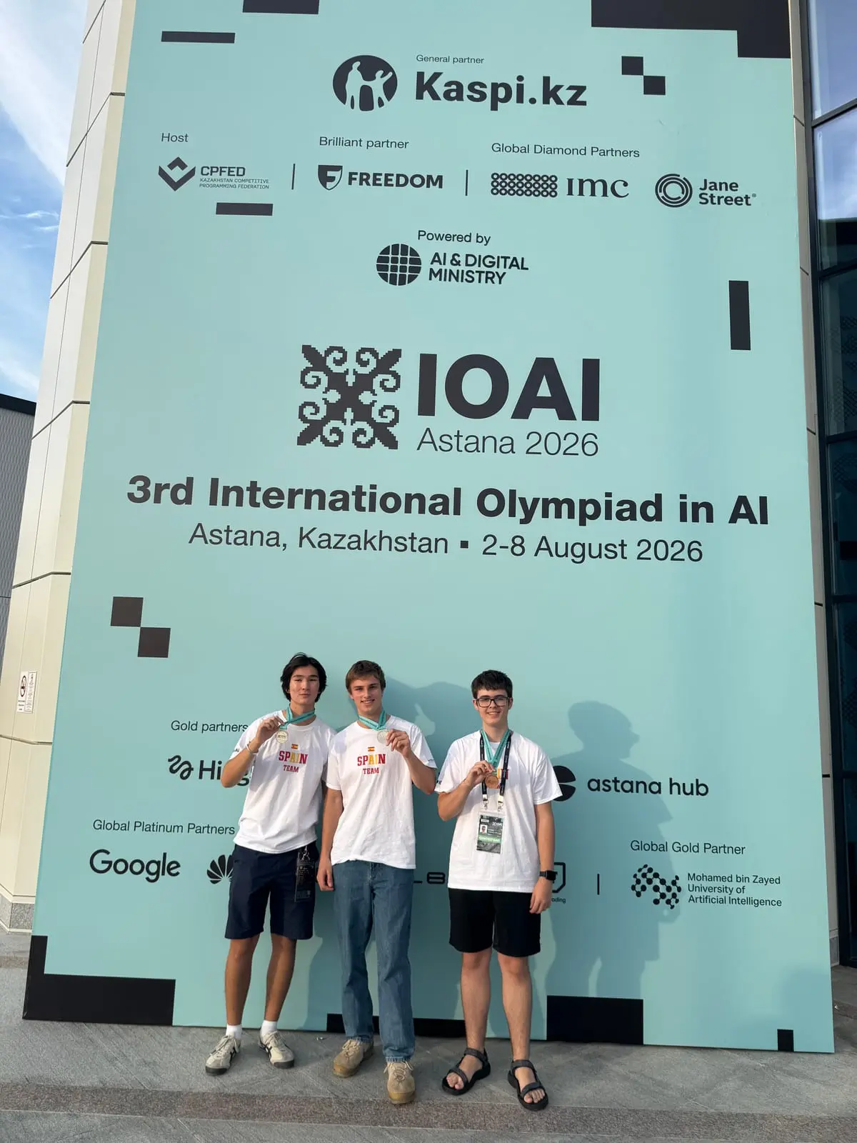 Medallists in front of the IOAI Astana 2026 banner.